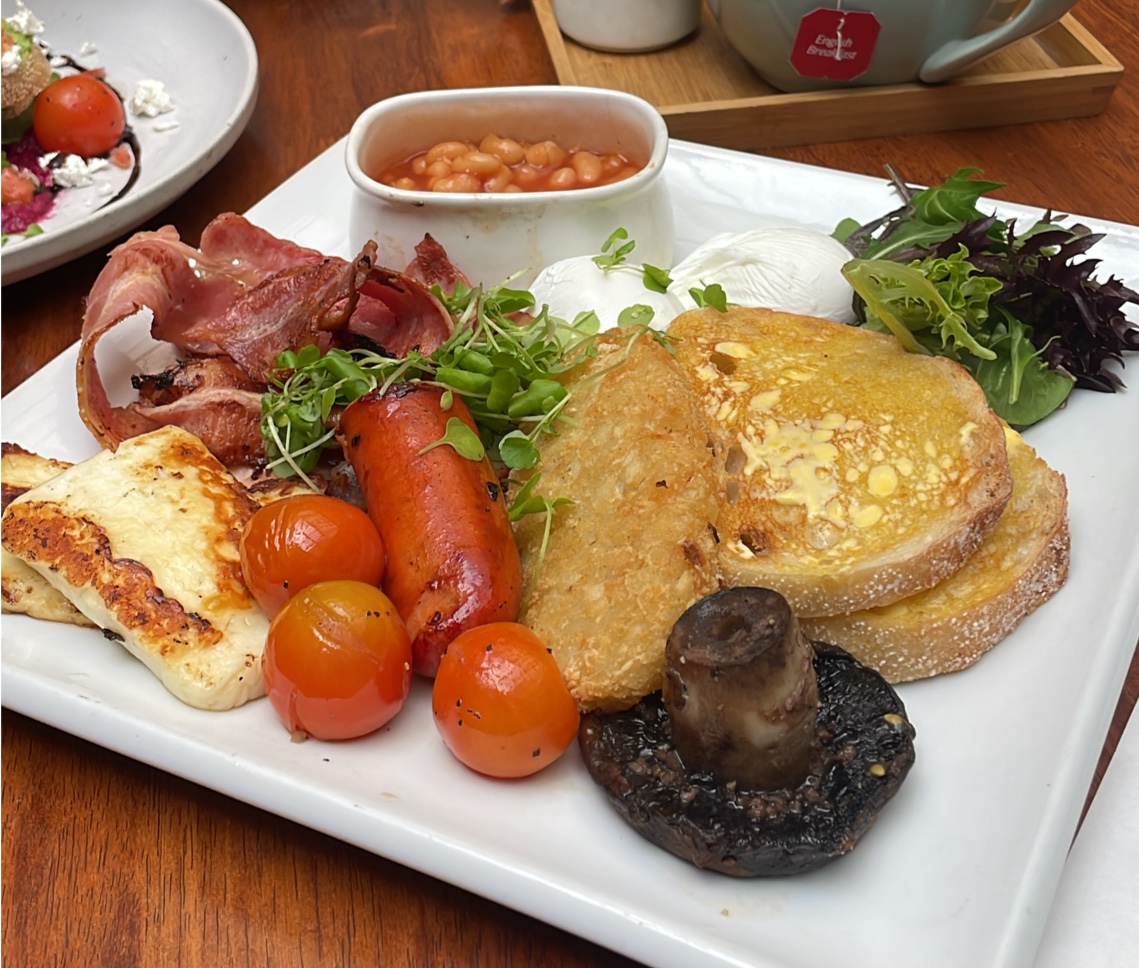 Big breakfast with bacon, sausage, halloumi, hash brown, mushroom, poached eggs and toast